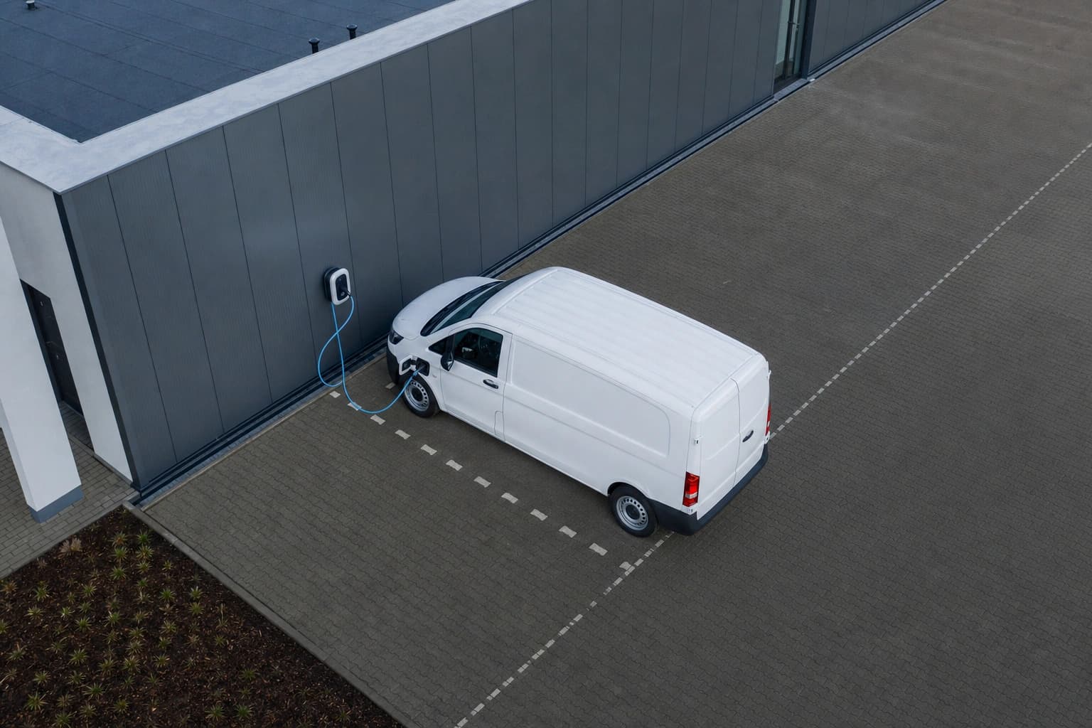 Elektrisches Firmenfahrzeug an einer Wallbox