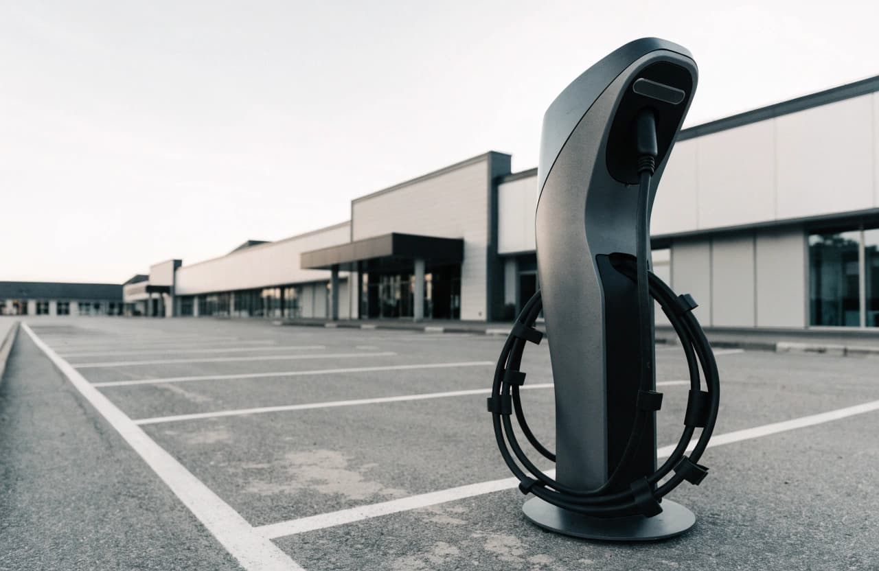 Einzelne HPC-Schnellladesäule auf dem Parkplatz eines Fachmarktzentrums.