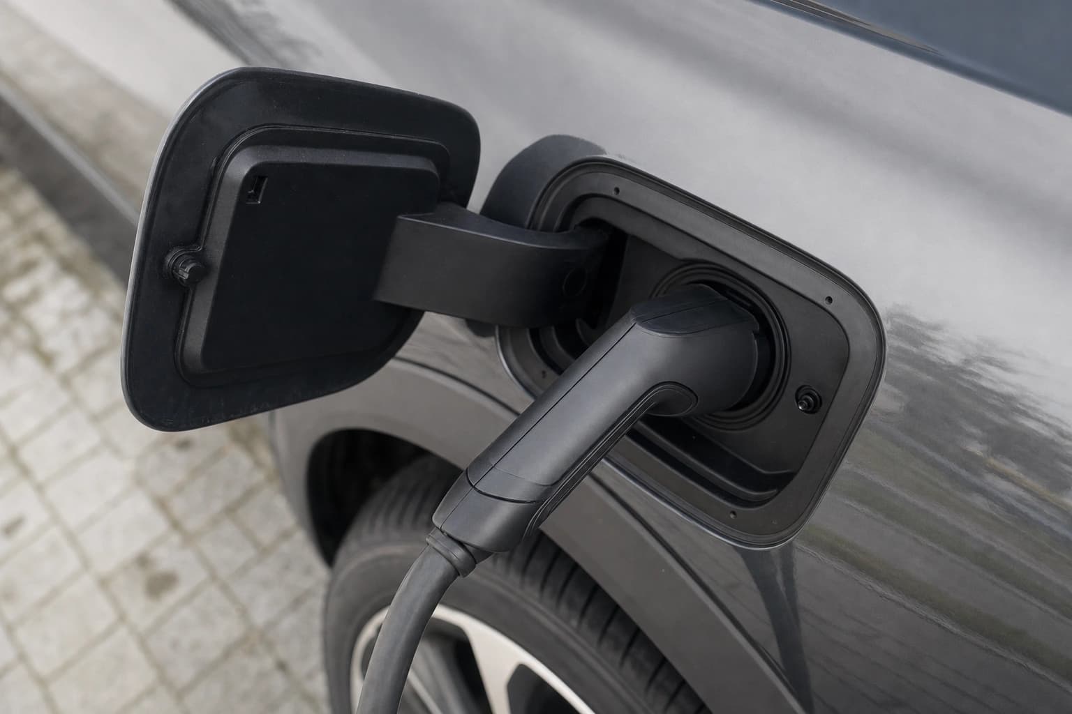 Ein Typ-2-Ladestecker, eingesteckt in den Ladeanschluss eines Elektroautos.