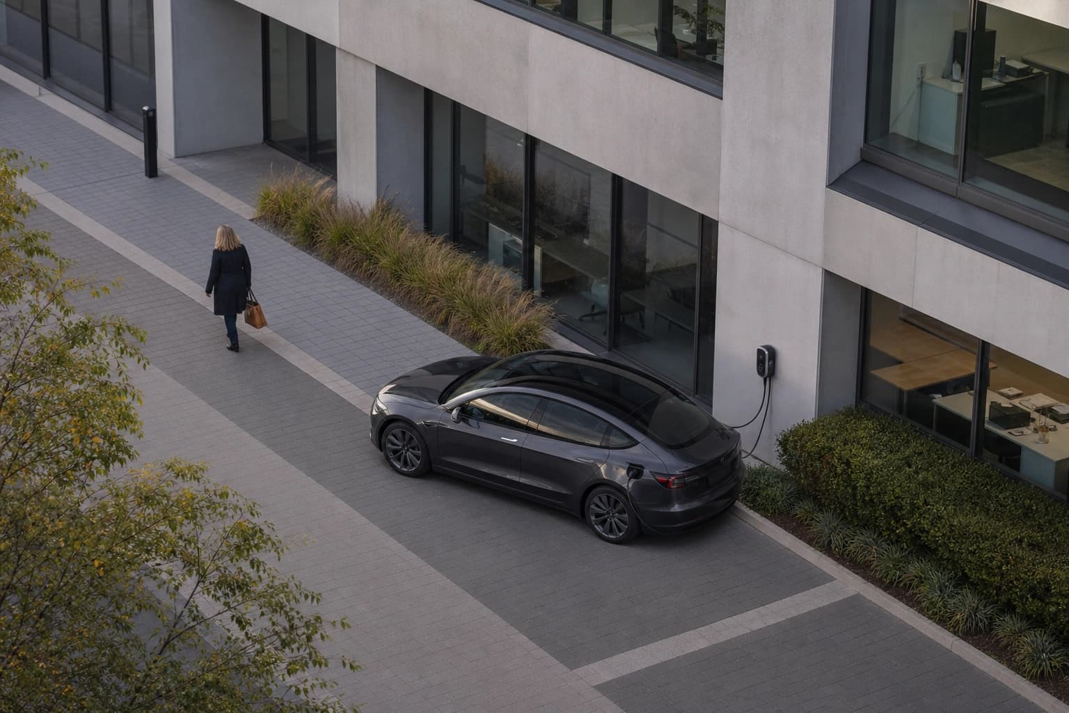 Elektroauto lädt an einer Wallbox auf einem Mitarbeiterparkplatz